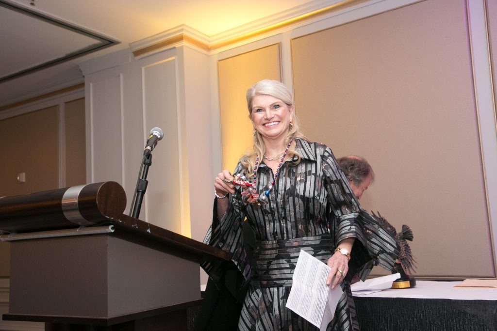 Blonde woman smiling at podium