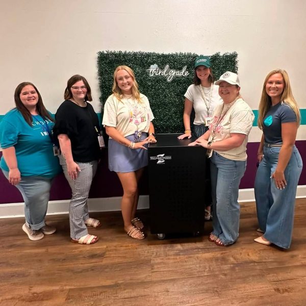 Group of women standing in front of technology cart