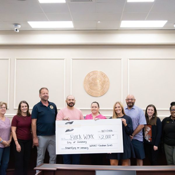 Group of people holding large check